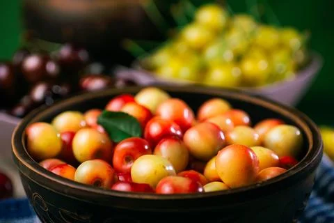 Multicolor cherries in the plate Stock Photos