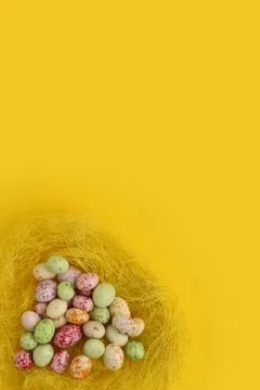 Multicolor decorated Easter eggs in a nest on a yellow background. Isolated. Stock Photos