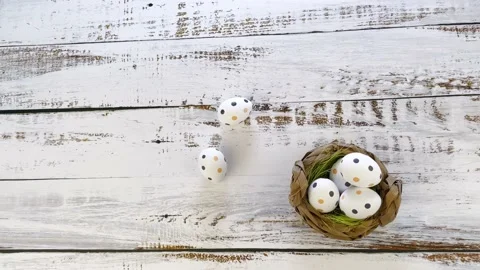 Multicolor Easter eggs rolling on white wooden table with tulips.  Stock Footage 150380567