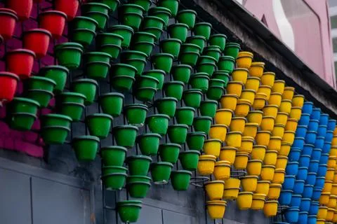 Multicolor empty flower pots on wall in row Fotos de archivo