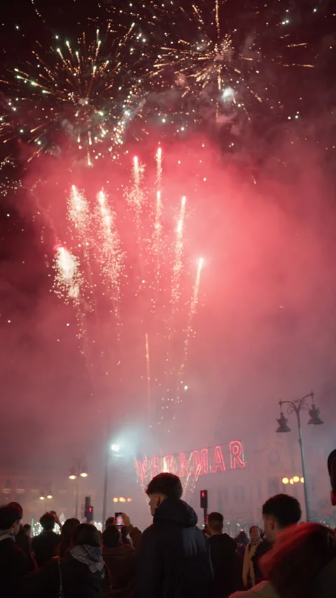 Multicolor firework burst over smoke-filled Valencia street Las Fallas night Stock Footage 334299843