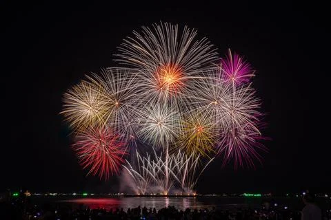 Multicolor Fireworks Display Exploding Over Coastal Waterfront Night Sky Wi.. Stock Photos