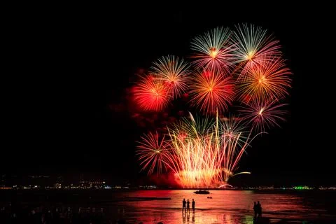 Multicolor Fireworks Exploding Over Ocean Beach At Night Pattaya Thailand W.. 库存照片