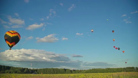 Multicolor Hot air balloon lighting up blue sky with clouds. 4K Stock Footage 157736054