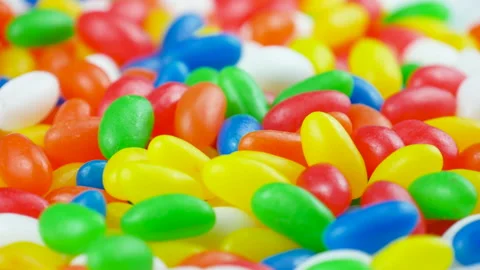 Multicolor Jelly Beans Candy Fall Down on Rotating Background Stock Footage 141441074