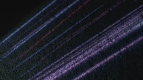 Multicolor light rays on black textured surface upper view Stock Footage 278712035