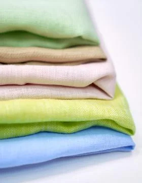 Multicolor linen cloth towels in stack on white table Stock-Fotos