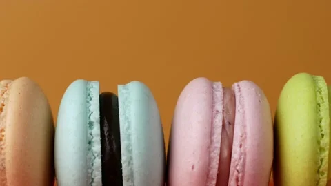 Multicolor Macarons, French macaroon, sweet tasty desserts. Isolated on a yellow Video stock 162259741