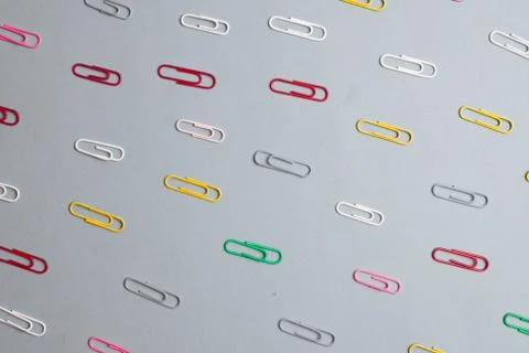 Multicolor paper clips on grey background. Back to school. Various color wire Stock Photos