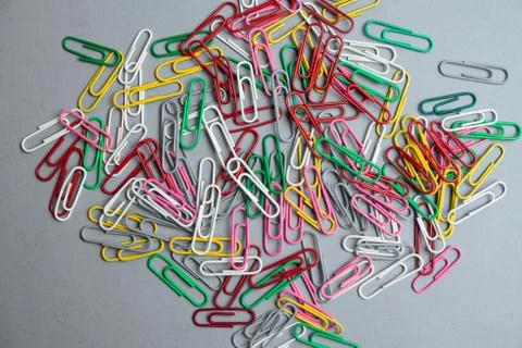 Multicolor paper clips on grey background. Back to school. Various color wire Stock Photos