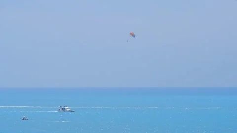 Multicolor parachute is hiding behind the boat. Parasailing, active form of recr Video stock 210205083