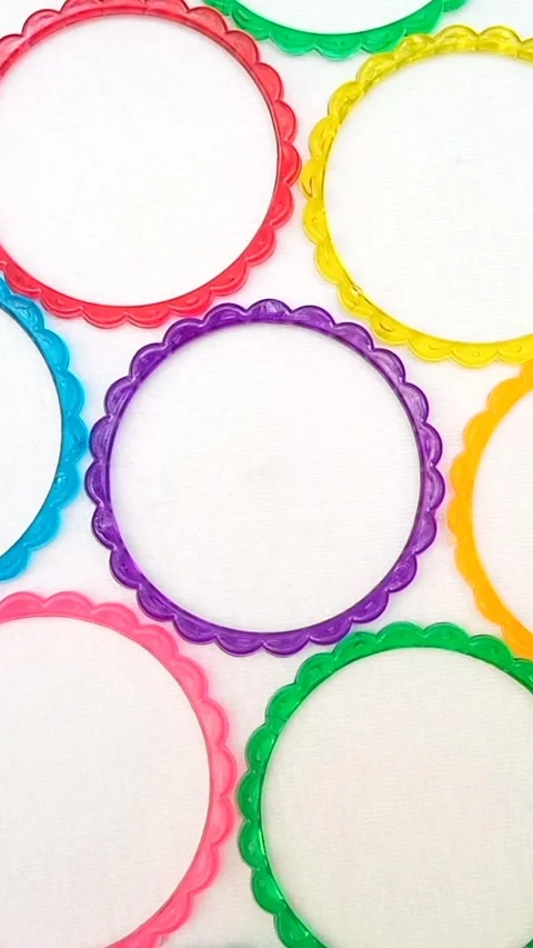 Multicolor plastic bangles rotating on white background, top view, accessory Stock Footage 320669410