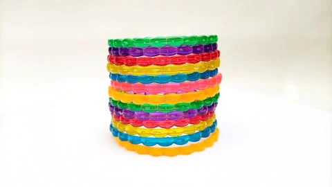 Multicolor plastic bangles set rotating on white background, fashion accessory Stock Footage 320669408