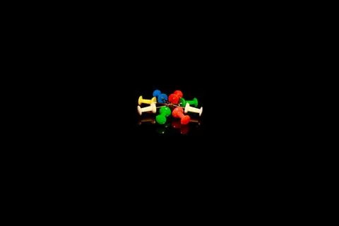 Multicolor Plastic Head Push Pins Thumbtacks isolated on black with reflections Stock Photos