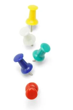 Multicolor push pins arranged in a row on white background Stock Photos