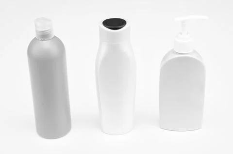 Multicolor refillable flip cap and pump cosmetic product packaging in row Stock Photos