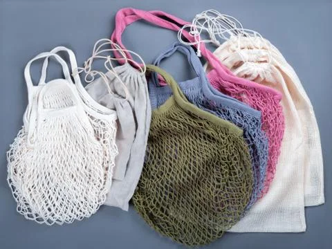 Multicolor reusable string bags and cotton sacks for different products. Stock Photos