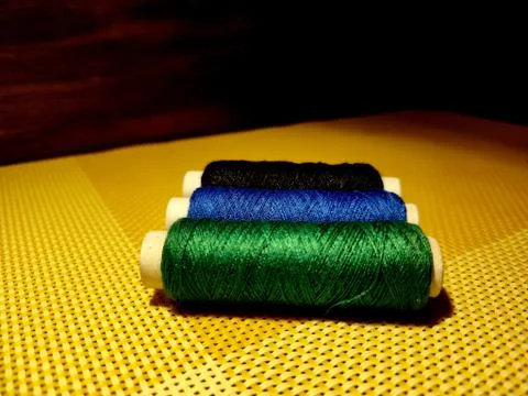 Multicolor sewing threads with dark background. Stock Photos