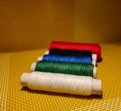Multicolor sewing threads with dark background. Stock Photos