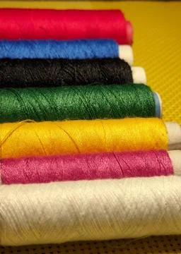 Multicolor sewing threads with dark background. Stock Photos