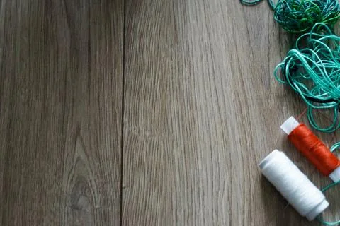 Multicolor sewing threads strings on wooden background. Stock Photos