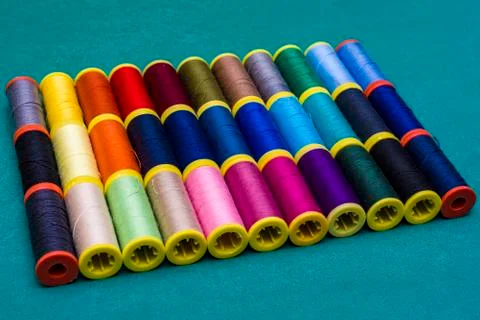 Multicolor sewing threads on wooden background Stock Photos