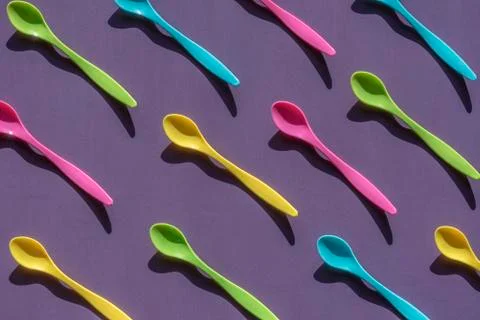Multicolor spoons on purple background Stock Photos