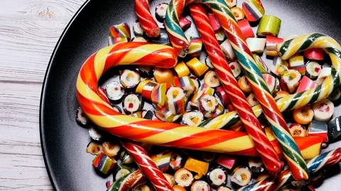 MultiColor Striped Caramel Candy On A Black Plate Panning Slider Shot. Stock Footage 121485077