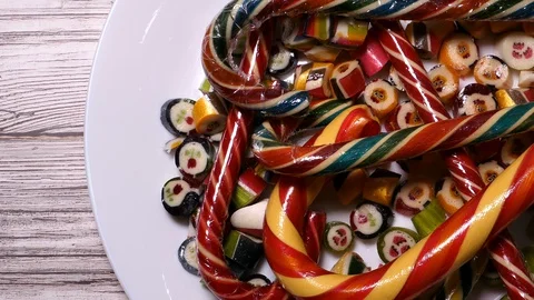 MultiColor Striped Caramel Candy On A White Plate Panning Slider Shot. Stock Footage 128552729