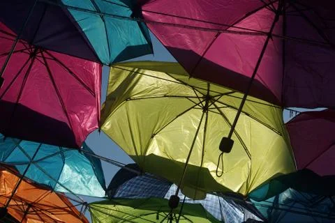 Multicolor umbrellas over a blue summer sky Stock Photos