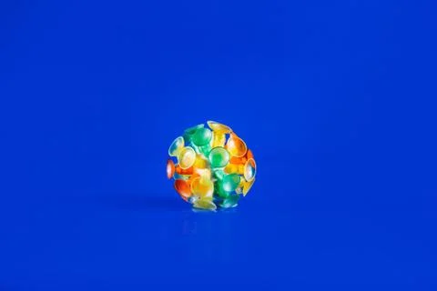 Multicolor virus isolated on a blue background. Toy recreation of covid-19 co Stock Photos