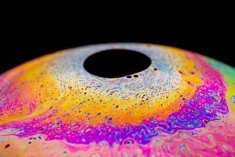 Multicolored abstract chaotic pattern inside of the soap bubble, closeup M... Stock Photos