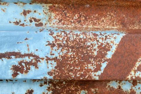 Multicolored background: rusty metal surface with blue paint flaking and crac Stock Photos