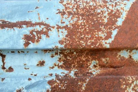 Multicolored background: rusty metal surface with blue paint flaking and crac Stock Photos