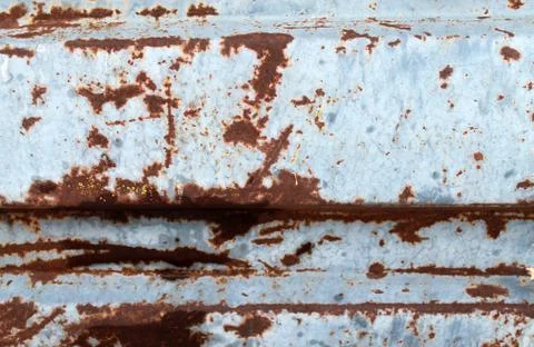 Multicolored background: rusty metal surface with blue paint flaking and crac Stock Photos