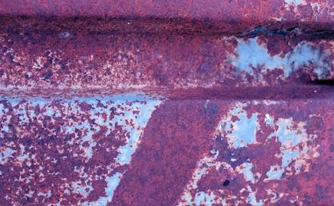 Multicolored background: rusty metal surface with blue paint flaking and crac Stock Photos