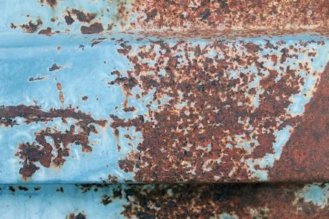 Multicolored background: rusty metal surface with blue paint flaking and crac Stock Photos