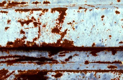 Multicolored background: rusty metal surface with blue paint flaking and crac Stock Photos