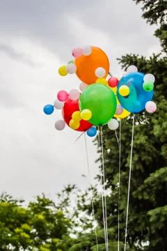 Multicolored balloons against the background of a cloudy sky Stock Photos