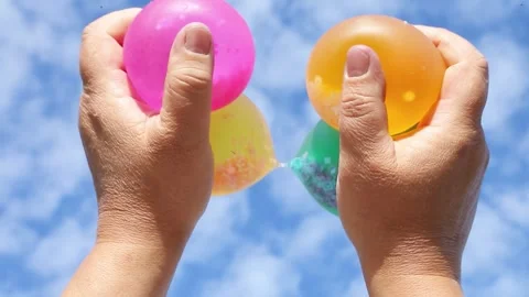 Multicolored balloons with beads pressed by hands Stock Footage 316151405