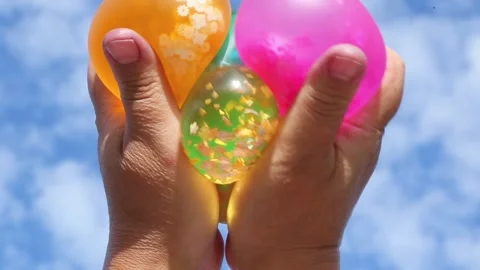 Multicolored balloons with beads squeezed outdoors Stock Footage 317159202