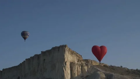 Multicolored balloons in the sky against the background of a white rock at sunri Stock Footage 151139119