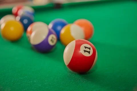Multicolored balls on billiard table for playing "eight", ball with number 11 Stock Photos