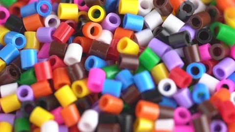 Multicolored beads falling down on white table. Beads background, close up. Stock Footage 268272721