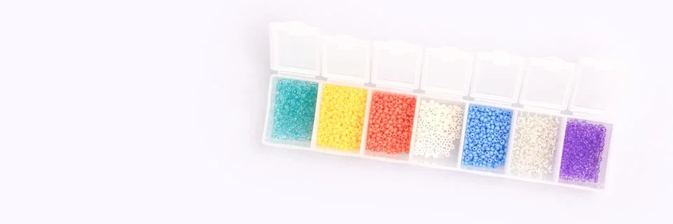 Multicolored beads in a storage container. Stock Photos