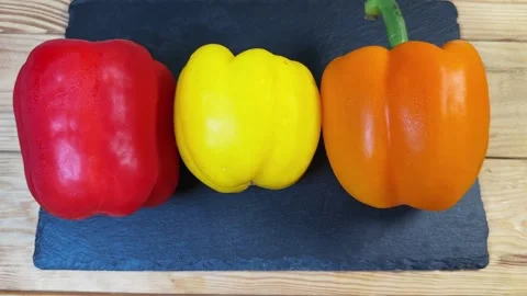 Multicolored bell peppers on a flat black slate serving plate 動画素材 337654522