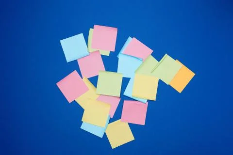Multicolored blank paper stickers of different colors on a dark blue backgrou Stock Photos