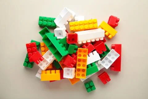 Multicolored blocks of the children's constructor lie on grey background. Stock Photos