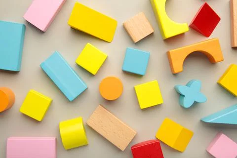 Multicolored blocks of the children's constructor lie on grey background. Stock Photos
