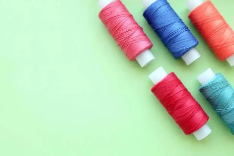 Multicolored bobbin of thread on a mint background Stock Photos